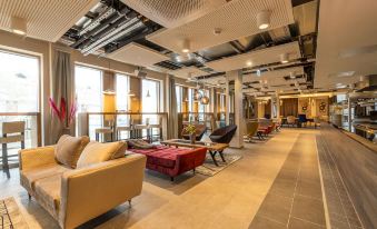 a modern , well - lit living room with multiple couches and chairs arranged in an open space at Maseven Muenchen Messe Dornach