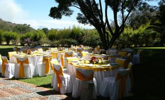 a large outdoor event with multiple tables set up for a wedding reception , surrounded by lush greenery at Hotel Rancho San Diego Grand Spa Resort