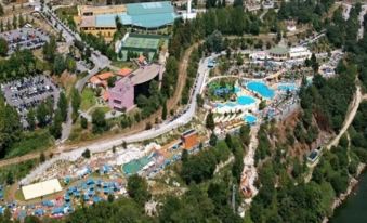aerial view of a water park with multiple pools , slides , and play areas surrounded by trees at Hotel Navarras