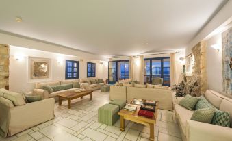 a spacious living room with multiple couches and chairs arranged in various positions , creating a comfortable and inviting atmosphere at Saint George Hotel