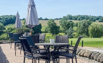 an outdoor dining area with a table and chairs set up for a group of people to enjoy a meal at Horsley Lodge