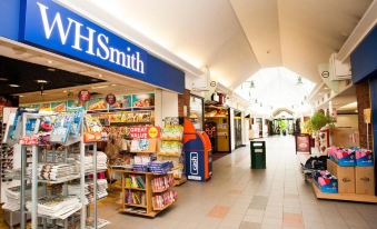 a shopping mall with a wh smith store prominently displayed in the center , surrounded by various items for sale at Days Inn by Wyndham Chesterfield Tibshelf