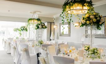 a well - decorated banquet hall with white chairs and tables , ready for a wedding reception or special event at Harbour Hotel & Spa Christchurch