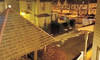 a residential area at night , with snow - covered streets and buildings illuminated by street lights , under a cloudy sky at Vandiver Inn