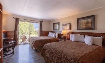 a hotel room with two beds , one on the left and one on the right side of the room at Yellowstone Valley Lodge, Ascend Hotel Collection
