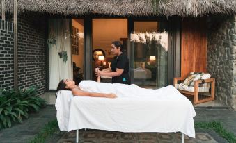 a woman is receiving a massage from a man in a spa setting , with the woman lying on a massage table at Hacienda la Danesa