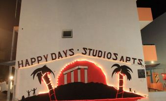 a building with a large mural of a beach scene on its side , illuminated at night at Happy Days