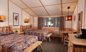 a room with two beds , one on each side of the room , and a dining table in the middle at Lake Lodge