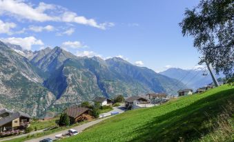 a scenic mountainous landscape with a village nestled in the valley , surrounded by lush green hills and towering peaks at Chalet Ninette