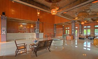 a large , well - lit room with wooden walls and ceiling , featuring a circular bench and two chairs at Danau Dariza Resort  - Hotel
