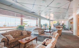 a large , open living room with multiple couches and chairs arranged in various positions , creating a cozy and inviting atmosphere at Ocean Gardens