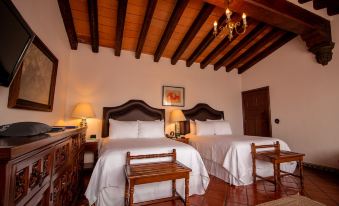 a hotel room with two beds , one on the left and one on the right side of the room at Las Mañanitas