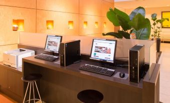 a modern office space with two computer workstations , each equipped with a monitor , keyboard , and mouse at Mitsui Garden Hotel Okayama