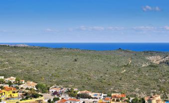 a picturesque view of a small village nestled in a valley with the ocean in the background at Esperanza