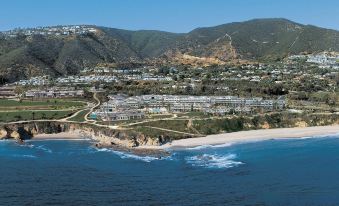 aerial view of a coastal town with mountains in the background , surrounded by ocean and sandy beach at Montage Laguna Beach