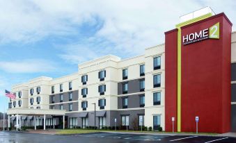 an exterior view of a hotel or motel building with a large parking lot in front of it at Home2 Suites by Hilton Long Island Brookhaven