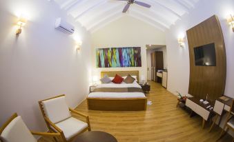 a modern bedroom with a large bed , wooden furniture , and a painting on the wall at Hondaafushi Island Resort