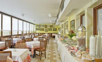 a large dining room with several tables and chairs , some of which are set up for a meal at Hotel Nazionale