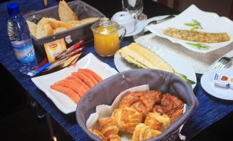 a table is set with a variety of breakfast foods , including croissants and carrots , as well as juices and condiments at Residence Maryka II