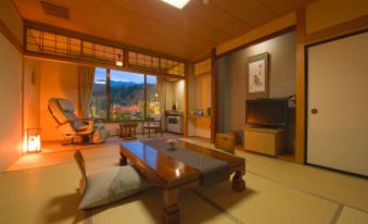 a japanese - style room with a tatami mat floor , wooden furniture , and a television in the background at Shikimitei Fujiya