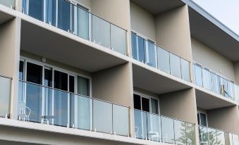 a modern apartment building with multiple balconies , giving it an open and airy feel during the day at Abode Malua Bay