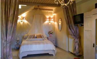 a well - decorated bedroom with a large bed , white curtains , and a television mounted on the wall at Villa Rosa