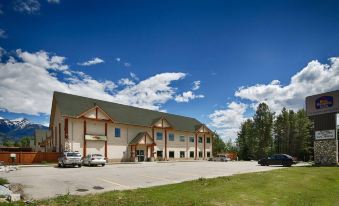 a large building with a parking lot in front of it and a blue sky above at Best Western Plus Valemount Inn  Suites
