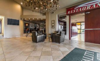 a hotel lobby with two leather chairs , a carpeted floor , and a chandelier hanging from the ceiling at Quality Inn & Suites Bay Front