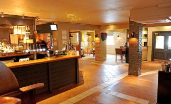 a spacious restaurant with a bar and dining area , featuring wooden flooring and large windows at York North West