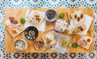 a wooden table is set with various dishes and bowls of food , including a salad at Santarena Hotel at Las Catalinas