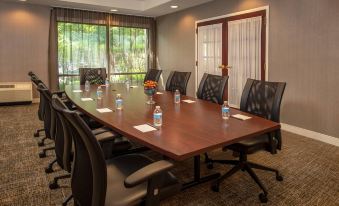 a conference room with a large wooden table , black chairs , and water bottles on the table at SpringHill Suites Centreville Chantilly