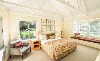 a spacious bedroom with a large bed , a couch , and a chair in the corner at Cape Lodge