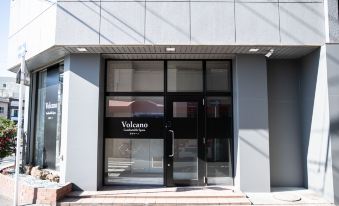 "a building with a black door and windows that say "" volcano "" in white letters on the side" at Volcano