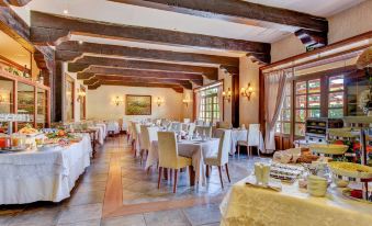 a large dining room with multiple tables and chairs , set for a formal dinner or a special occasion at Hotel Spa Villalba