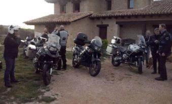 a group of motorcyclists is gathered in front of a house , waiting for their turn to ride at La Contrada