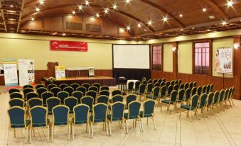 a conference room with rows of chairs and a large screen at the front , ready for an event at Hotel Diplomat