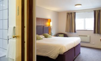 a well - lit hotel room with a large bed , curtains , and a window , giving it a cozy and inviting atmosphere at Hello Hotel