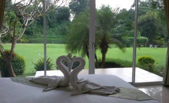 a bed with a white towel in the shape of a heart on top of it at Vimannam Resort