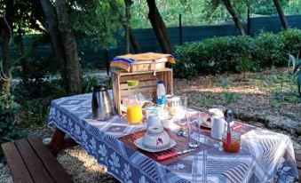 a picnic table with a blue and white tablecloth , plates , cups , and utensils on it at L'Atelier