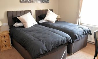 two twin beds with blue sheets and white pillows are placed side by side in a bedroom at The Red Lion