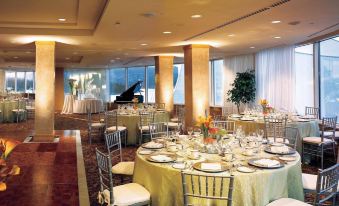 a well - decorated banquet hall with multiple round tables and chairs , as well as a piano in the background at Pan Pacific Vancouver
