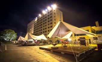 a large white tent set up in a parking lot with several smaller tents and tents surrounding it at Naeba Prince Hotel