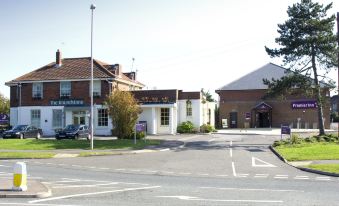 "a brick building with a sign that says "" may vale country cottages "" is next to a parking lot" at Premier Inn Littlehampton