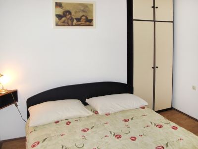 a neatly made bed with a floral comforter and two white pillows is shown in a bedroom at Ingrid