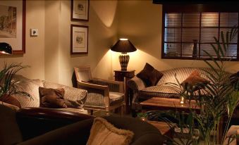 a cozy living room with several chairs and couches arranged in various positions , creating a comfortable atmosphere at Hotel Manor Windsor