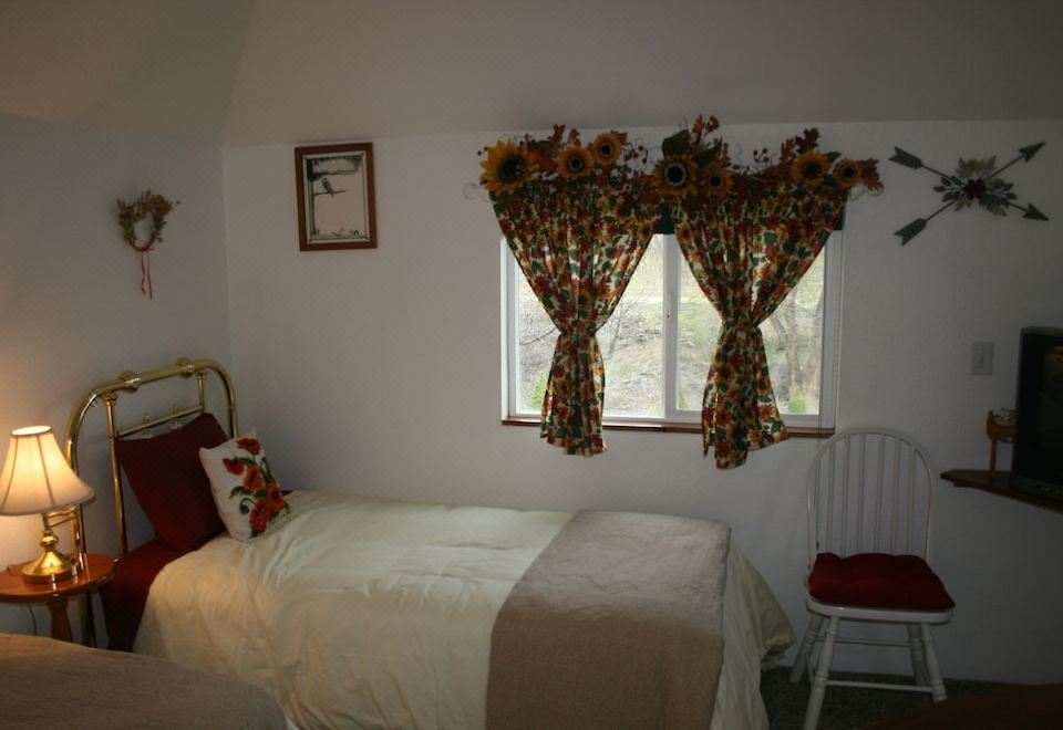 a small bedroom with a bed and window curtains , creating a cozy and inviting atmosphere at Dreamcatcher Bed and Breakfast