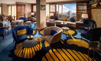 The hotel's suite includes a spacious living room with large windows and furniture, including couches on both sides at Sofitel Saigon Plaza