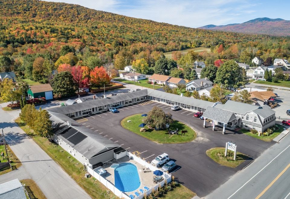 a parking lot with a blue pool in the middle surrounded by buildings and trees at Top Notch Inn