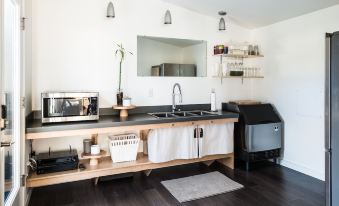 a kitchen with a sink , stove , and counter has a microwave , coffee maker , and trash can at Lodges on Vashon