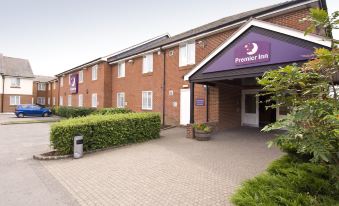 a premier inn hotel building with its entrance and surrounding area , including a brick - paved driveway and greenery at Swindon North